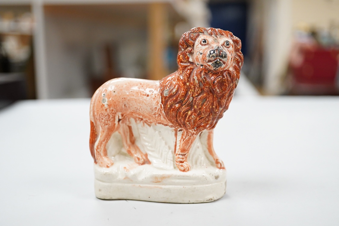 A rare Staffordshire Pearlware model of a recumbent lion, c.1810, and three Staffordshire pottery models of lions, mid 19th century, largest 11cm wide